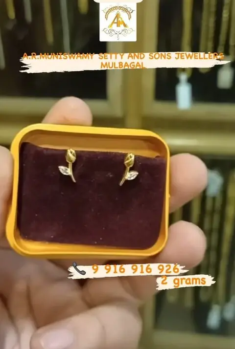 A pair of small rose stud earrings in a velvet box.